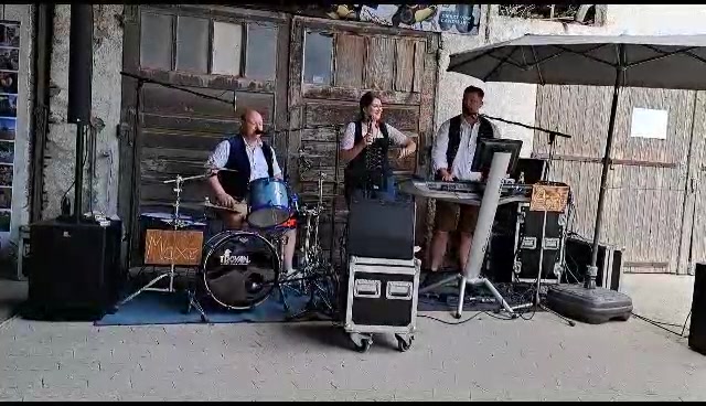 Hochzeitsband, Oktoberfestband und Eventband Out of Minga mieten / buchen, Trio Sommerfest mit Stadl im Hintergrung